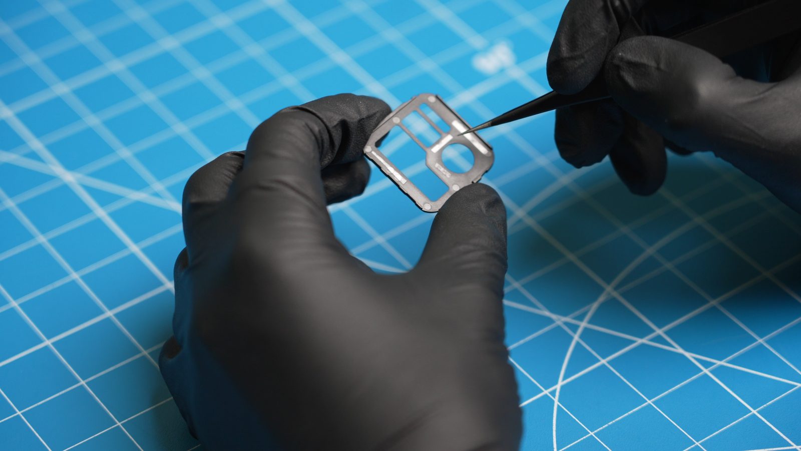 Placing double-sided tape on the back of the Casio AE-1200 faceplate with tweezers